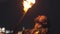 Bearded man performer playing with fire - spits gasoline on the fire