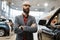 Bearded man poses at pickup truck, car dealership