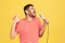 Bearded man professional musician in striped t-shirt singing songs holding microphone, closing eyes and opening soul, rehearsal