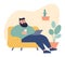 Bearded man relaxing on couch with laptop and coffee. Casual male enjoys leisure time indoors. Comfortable home setting