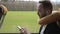 Bearded man rides bus, holding smartphone and listening to music on headphones.