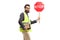Bearded man in a safety vest holding a stop traffic sign and books