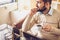 Bearded man sitting with cup of morning coffee and looking out the window