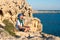 Bearded man sitting on a rocky shore