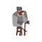 Bearded man sitting on wooden chair leaning on ax and thinking. Thoughtful lumberjack in gray sweater, blue jeans and