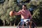 Bearded man in sports wheelchair dribbling basketball