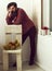 Bearded man standing at chair with teddy bear