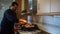 Bearded man stirring chicken and pork meat in a paella