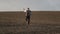 Bearded man in a suit in the field barefoot.