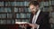 Bearded Man in Suit Reading Book in Library