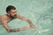 Bearded man swimming in blue water. Summer vacation and travel to ocean. Relax in spa swimming pool, refreshment and