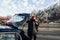 Bearded man taking his backpack out of the car trunk overlooking the mountains in Mittenwald, Germany