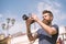 Bearded man taking photo on sunny day. Man with beard and mustache on concentrated face, sky on background, defocused