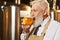 Bearded man tasting light beer in brewery