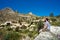 Bearded man traveler sitting on a edge