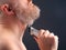 Bearded man with trimmer to adjust beard in hand