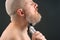 Bearded man with trimmer to adjust beard in hand