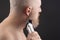 Bearded man with trimmer to adjust beard in hand