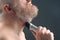 Bearded man with trimmer to adjust beard in hand