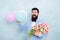 Bearded man with tulips. Spring party. Surprise party romantic proposal ideas. Present for spouse. Guy with air balloons