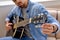 bearded man tuning acoustic guitar at home, Young guitarist fixing tuning pegs close-up