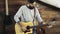 Bearded man tuning an acoustic guitar slow motion