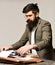 Bearded man type on typewriter. Man with long beard and mustache typewrite research paper. Businessman in suit work as