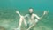 A bearded man without underwater equipment underwater pretends to meditate in the sea. Slow motion