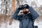 Bearded Man Using Binoculars While Winter Forest Trip