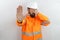Bearded man wearing hardhat and reflecting jacket in shock covering face and eyes with hand with embarrassed expression and doing