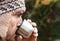 Bearded man in wool knitted hat drinks from mug, face in profile