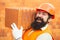 Bearded man worker, beard, building helmet, hard hat. Builders in hard hat and gloves. Portrait of happy worker. Bearded