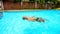 Bearded Old Man Swims on Back along Oval Swimming Pool