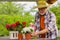 Bearded retired man getting satisfaction while watering plants