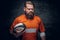 Bearded rugby player holds game ball.