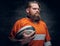 Bearded rugby player holds game ball.