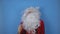 Bearded santa claus dancing and fooling around on camera on a blue background. New Year and Christmas concept