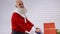 Bearded Santa Claus pushing shopping trolley with presents