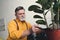 bearded senior man putting soil in pot