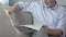 Bearded senior man sitting on couch and reading newspaper, weekend morning news