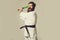 Bearded shouting karate man in kimono with green baseball bat