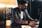 Bearded student working process in loft office at night. Young man sitting sits by the table with lamp using modern laptop