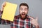 Bearded Surprised man in shirt holding blank board