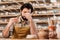 bearded tired potter in apron sitting in workshop with ceramic dishware