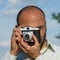 Bearded tourist man photographs an old film camera.
