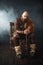 Bearded viking with axe sitting on chair