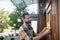 Bearded waiter in grey apron hanging open sign on the door