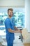 Bearded young doctor in putting envelope in standing file folder, smiling