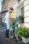 Bearded young male cutting leaves outside flower shop