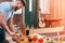 Bearded young man cutting onion for barbecue